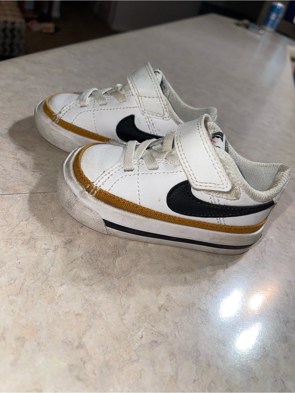 Nike Kids White Sneakers with Black Swoosh and Gold Accent
